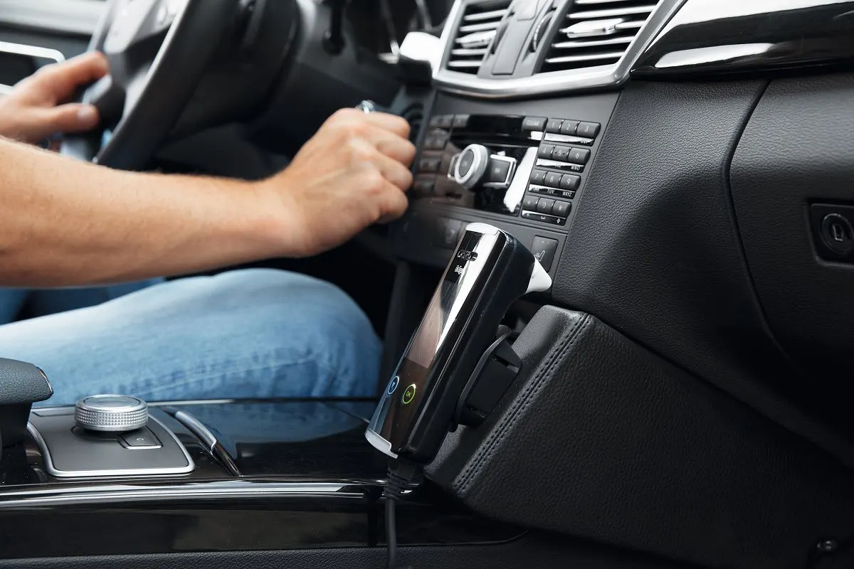 Driver's hand near an ignition interlock handset mounted in a car console
