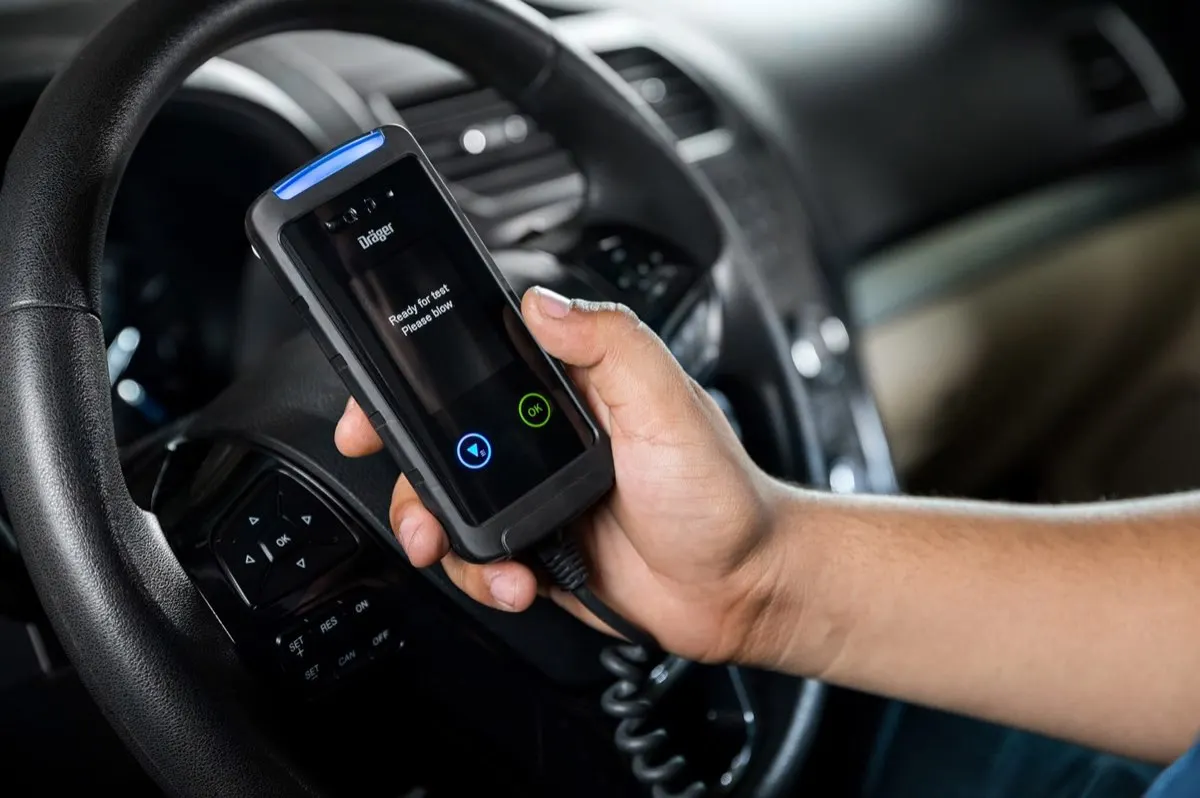 Driver holding an interlock handset ready for a breath test