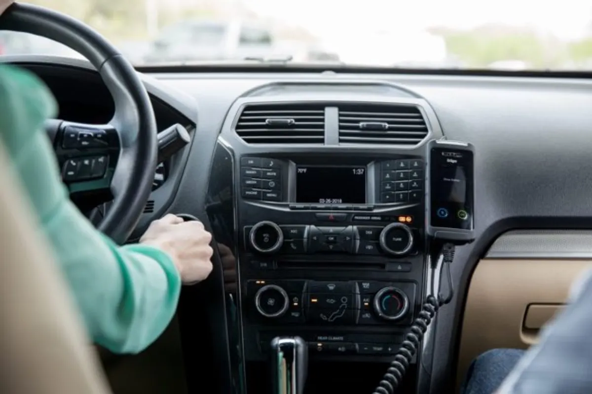Driver starting a car with an ignition interlock mounted on the dashboard, the kind of vehicle many drivers use for an interlock driving test